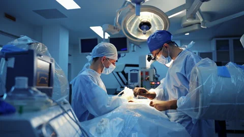 Surgeons working on patient in operating room. Video stock 145726664