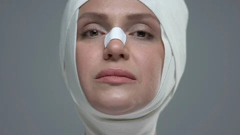 Surgery and injection instruments in front of woman face in elastic bandage 動画素材 117390596