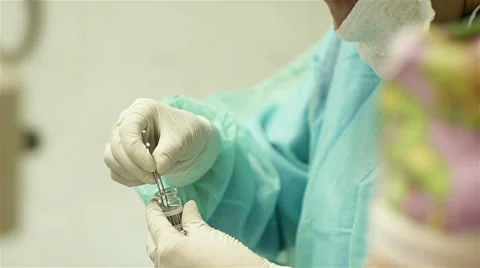 Surgery, the assistant pulls out the flask of artificial crystalline lens Stock Footage 57781721