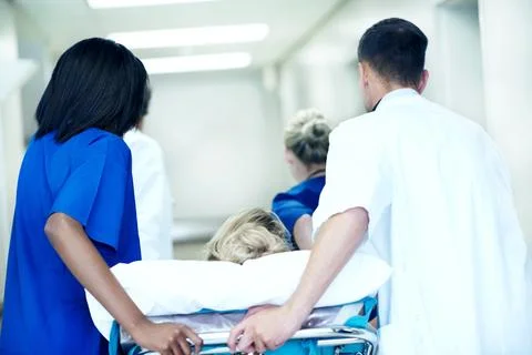 Surgery, emergency and back with doctors in hospital for running, medical crisis Stock Photos