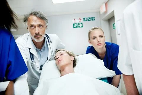 Surgery, emergency and team with doctors in hospital for running, medical crisis Stock Photos