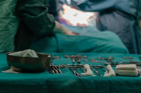 Surgery instruments on table with doctor on background Stock Photos
