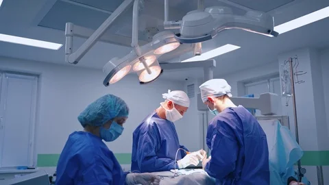 Surgery process. Group of surgeons doing an operation to a patient  Stock Footage 125894840