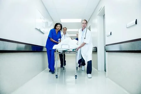 Surgery, running and corridor with doctors in hospital for accident, medical cri Stock Photos