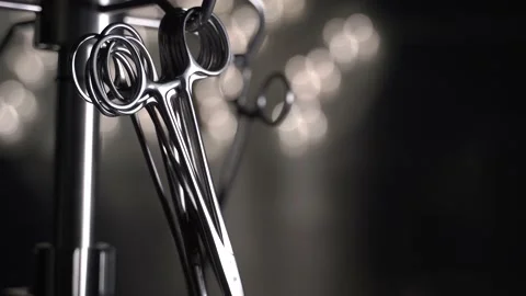 Surgery scissors close up footage with worling surgical lamps in a surgery room 스톡 동영상 219950440