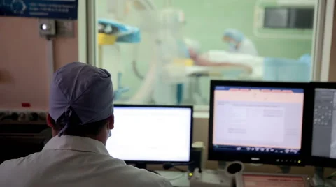 Surgery. Unrecognizable doctor controls operation performing in hospital Stock Footage 65246473