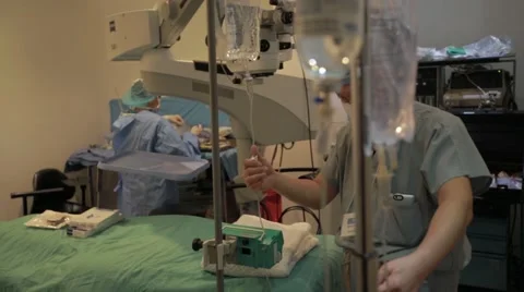 Surgical assistant adjusting iv drip in operation theatre Stock Footage 62388107