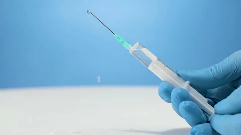 Surgical assistant prepares injection needle, push air out of plastic Stock Footage 238497822