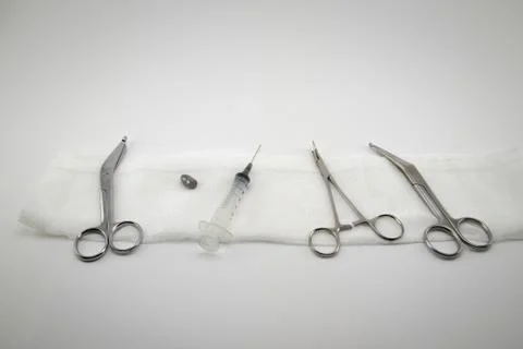 Surgical composition with forceps, scissors, syringe and one bullet Stock Photos