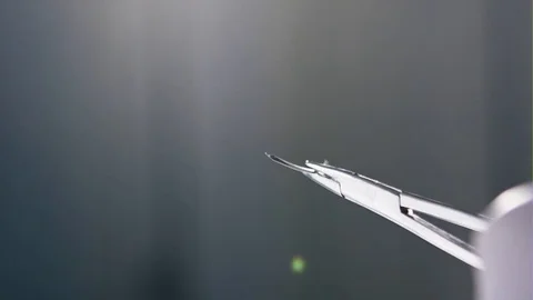 Surgical forceps holding a suture needle - slow motion Stock Footage 74368395