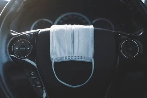 Surgical mask placed on steering wheel 스톡 사진
