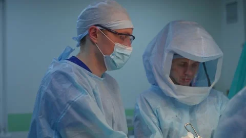 Surgical procedure. Doctors in protective uniform working in the operating room. Stock Footage 135399960