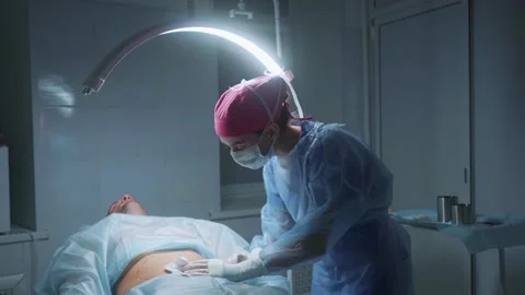 Surgical procedure in a modern operating room during late hours showcasing Stock-Footage 295864156