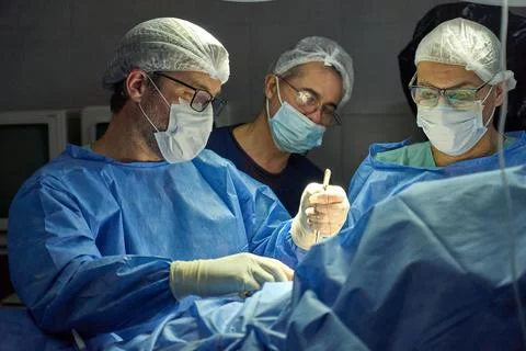 Surgical procedure in progress in a sterile operating room Stock Photos