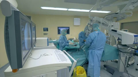 Surgical process carried out by a team of doctors in a modern operational room Stock Footage 98650899