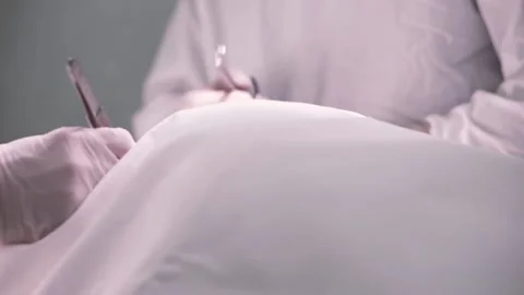 Surgical process by specialists. Doctors' hands in white sterile gloves working Stock Footage 132099611