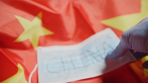 Surgical protective mask lying on a flag. Flu and Corona Virus. China Flag. Stock Footage 126904462