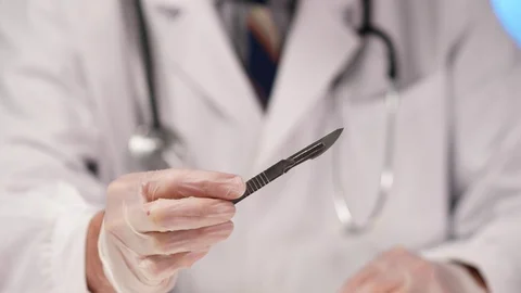 Surgical Scalpel Being Showed by a Doctor Closeup Stock Footage 128380439