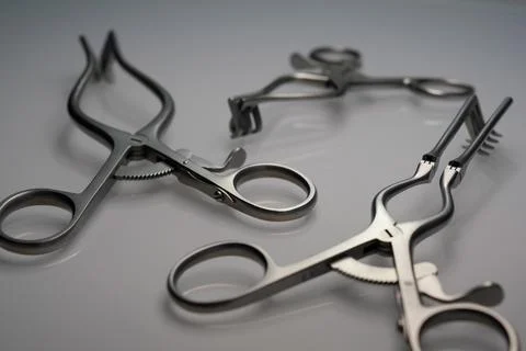 Surgical Spreader Instruments On Reflective Gray Surface Stock Photos