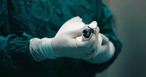Surgical stapler in the operating theater with clean &amp; bloody surgeon gloves Stock Footage 126945272