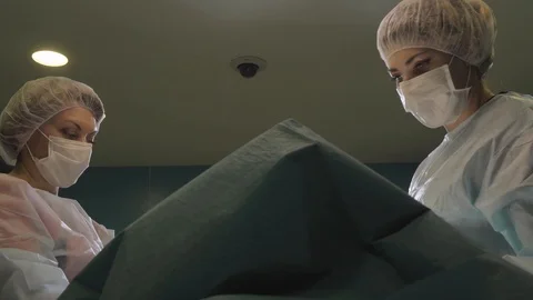 Surgical team are performing surgery on breasts in hospital operating room. Видео 89955087