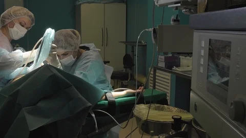Surgical team are performing surgery on breasts in hospital operating room. Видео 89955176