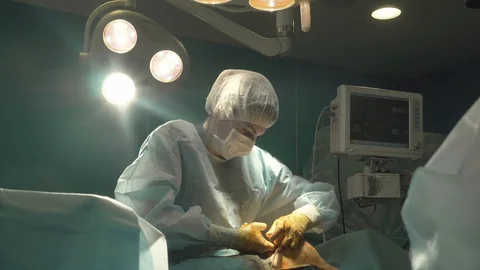 Surgical team are performing surgery on breasts in hospital operating room. Видео 89955206