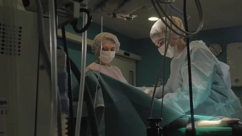 Surgical team are performing surgery on breasts in hospital operating room. Видео 89955317