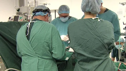 Surgical team doing open heart surgery in modern operating room Stock Footage
