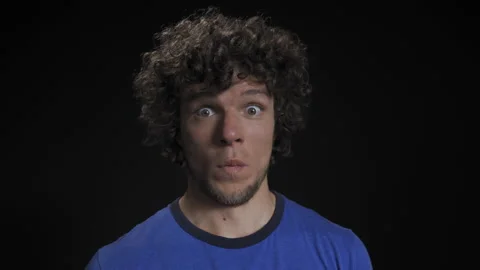 Surprise. A middle-aged man in curls is surprised on a black background. Stock Footage 142647780