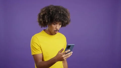 Surprised african man looking the screen of a mobile Video stock 234856408