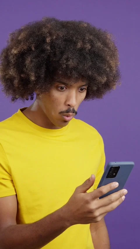 Surprised african man looking the screen of a mobile Stock Footage 242333765