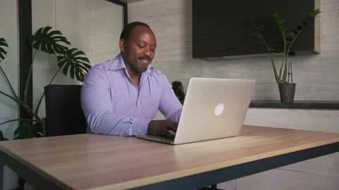Surprised African man makes video call with parents using laptop  Stock Footage 201292546