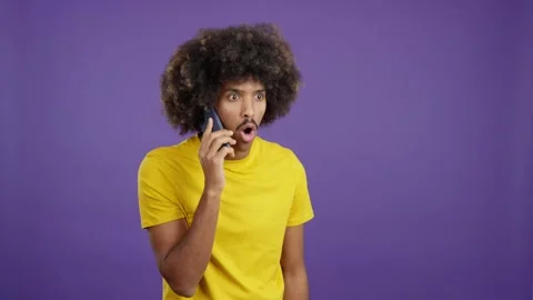 Surprised african man talking to the mobile Stock Footage 234113804
