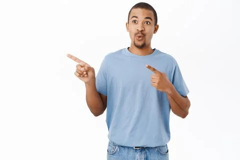 Surprised arab guy pointing left, shows direction, say wow, impressed by Photos