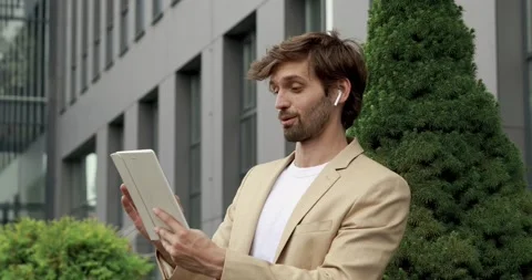 Surprised bearded man dressed in stylish suit looking at screen of digital Stock Footage 137744259