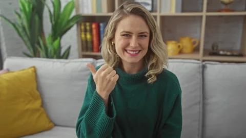 Surprised blonde bombshell on sofa, finger-pointing in a-ha moment! beautif.. Stock Footage 279380806