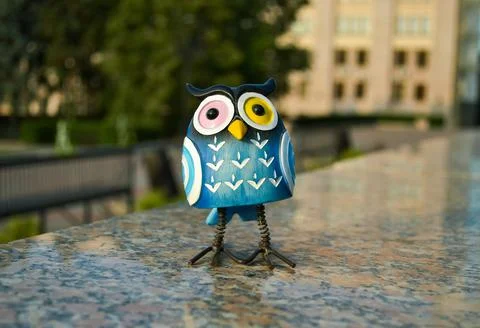 A surprised blue owl with multi-colored eyes stands close-up Stock Photos