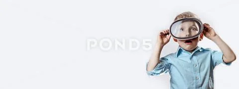 A surprised boy in a blue shirt wearing an underwater mask for swimming on a Stock Photos