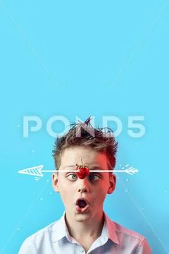 Surprised boy with a falling strawberry squinted his eyes to his nose on a bl Stock Photos