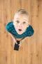 The surprised boy look up and hold a phone. View from above Photo