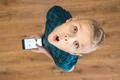 The surprised boy look up and hold a phone. View from above Photo