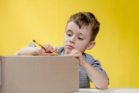 Surprised boy looking opening a box and gasping in surprise seeing the conten Stock Photos