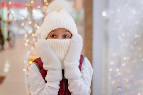 Surprised boy in white bobble hat and scarf at mall near showcase. blurred Stock Photos