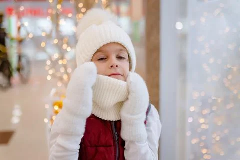 Surprised boy in white bobble hat and scarf at mall near showcase. blurred Stock Photos