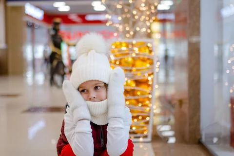 Surprised boy in white bobble hat and scarf at mall near showcase. blurred Stock Photos