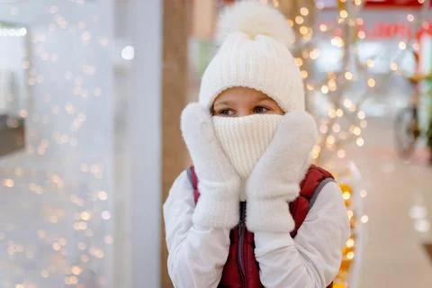 Surprised boy in white bobble hat and scarf at mall near showcase. blurred Stock Photos