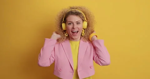 Surprised cheerful curly haired young woman says wow opens mouth feels impressed Stock Footage 154811642