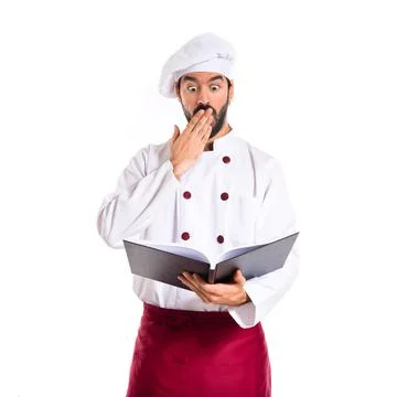 Surprised chef reading a book Stock Photos