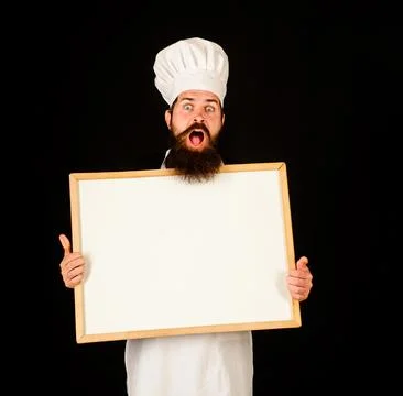 Surprised chef showing empty menu whiteboard with copy space for text. Food s Stock Photos